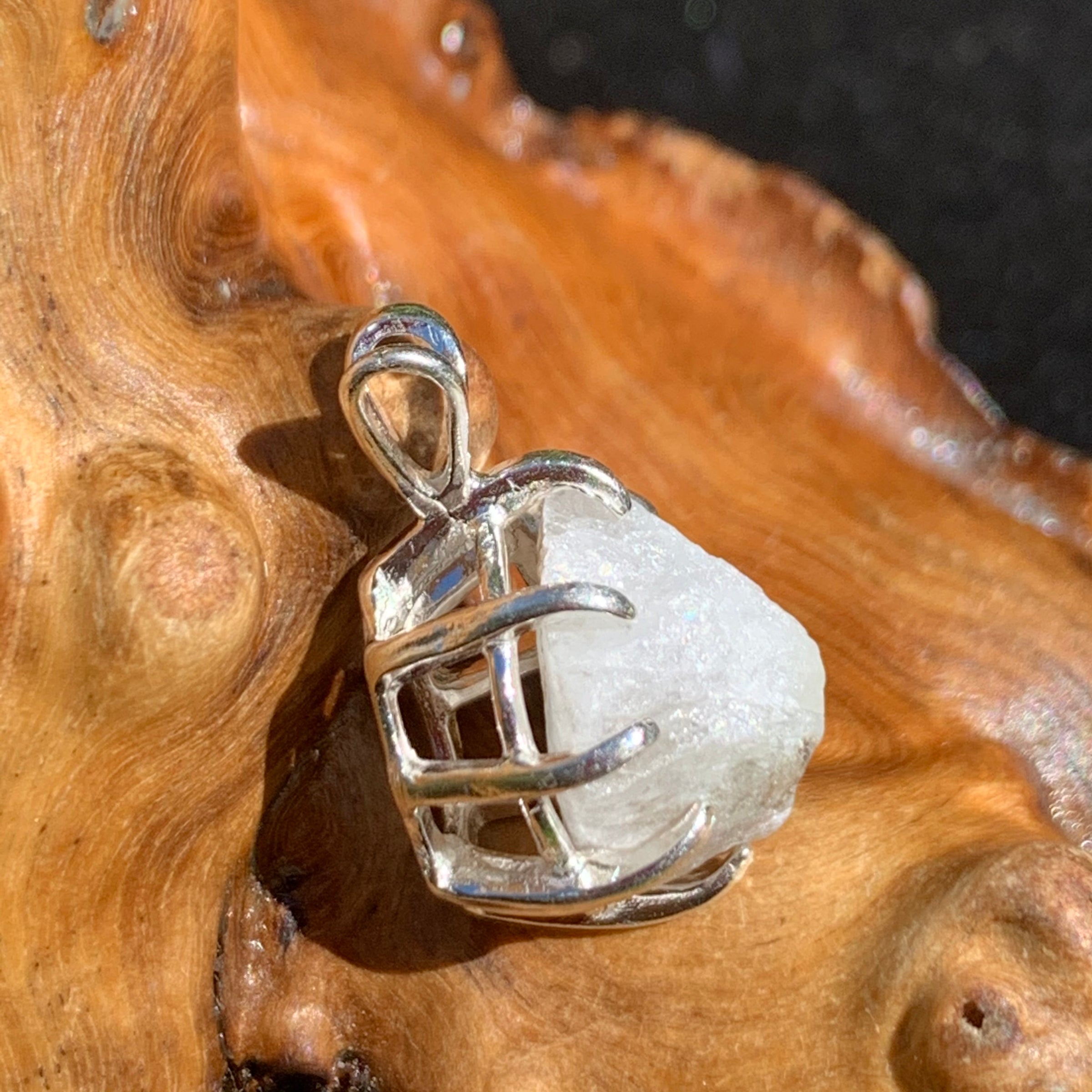 sterling silver Russian phenacite basket pendant sitting on driftwood for display