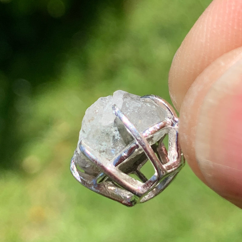 sterling silver Russian phenacite basket pendant held up on display
