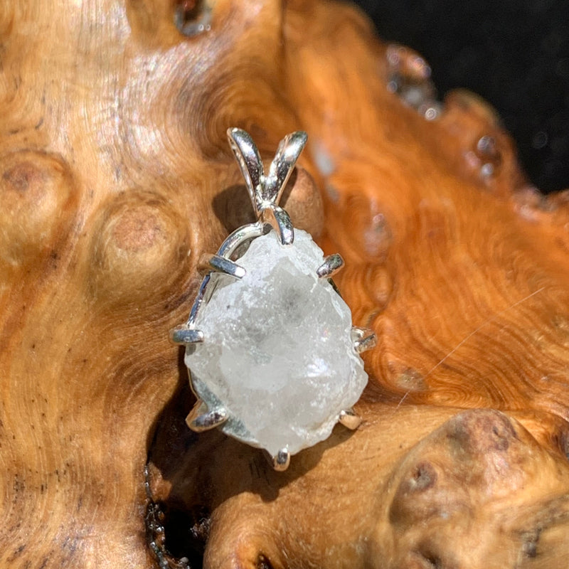 sterling silver moldavite tektite and Russian phenacite basket pendant sitting on driftwood for display