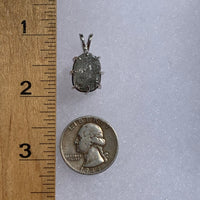 sterling silver moldavite tektite and Russian phenacite basket pendant next to a ruler and US quarter for scale