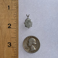 sterling silver moldavite tektite and Russian phenacite basket pendant next to a ruler and US quarter for scale