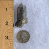 Gray quartz point with black brookite in matrix next to ruler and quarter for scale