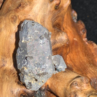 Gray quartz cluster with black brookite in matrix displayed on driftwood