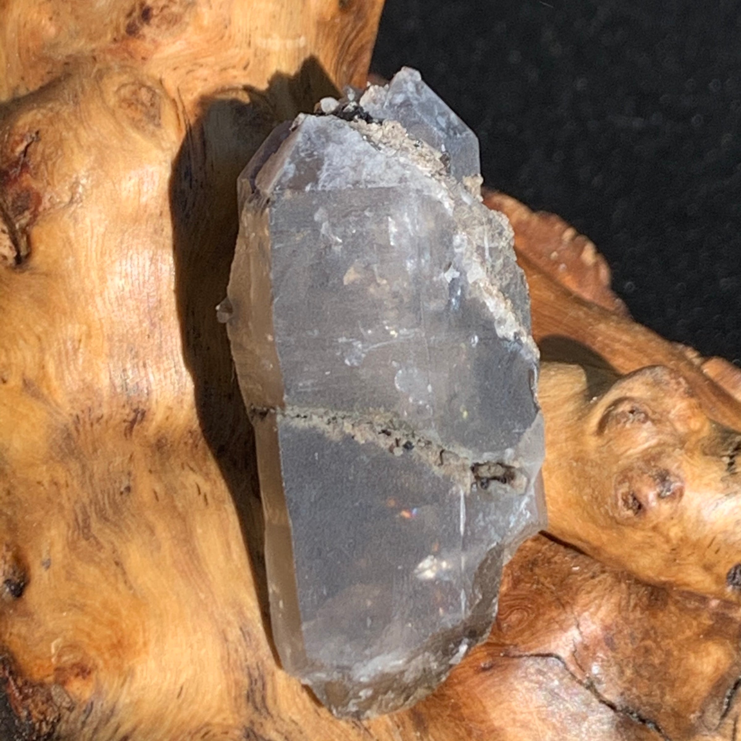 medium and tiny brookite crystals on a triple pointed smokey quartz sitting on driftwood for display