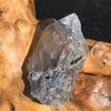 medium and tiny brookite crystals on a smokey quartz point sitting on driftwood for display