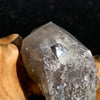 medium and tiny brookite crystals on a smokey quartz point sitting on driftwood for display