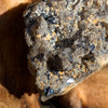 close up view of small brookite crystals on a smokey quartz cluster sitting on driftwood for display