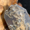close up view of tiny brookite crystals on a smokey quartz point sitting on driftwood for display