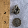 tiny brookite crystals on a smokey quartz point cluster next to a ruler and a quarter for scale