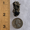large and tiny brookite crystals on a smokey quartz cluster next to a ruler and a quarter for scale