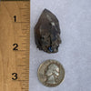 small and tiny brookite crystals on a smokey quartz point next to a ruler and a quarter for scale