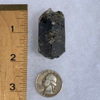 medium, small, and tiny brookite crystals on a smokey quartz cluster next to a ruler and a quarter for scale