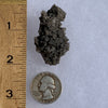 tiny brookite crystals in a smokey quartz cluster next to a ruler and a quarter for scale