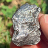 silver campo del cielo meteorite held in hand to show details