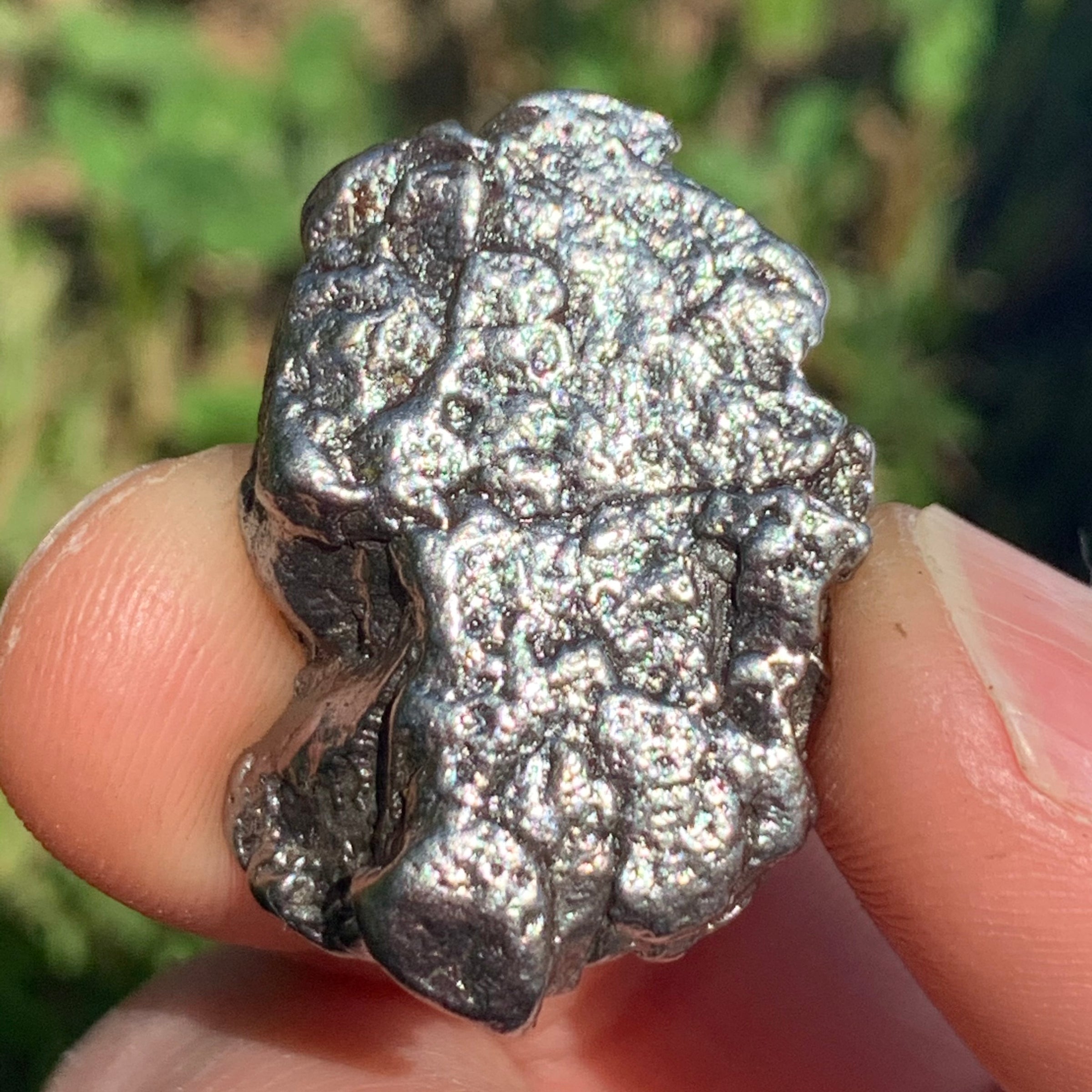 silver campo del cielo meteorite held in hand to show details
