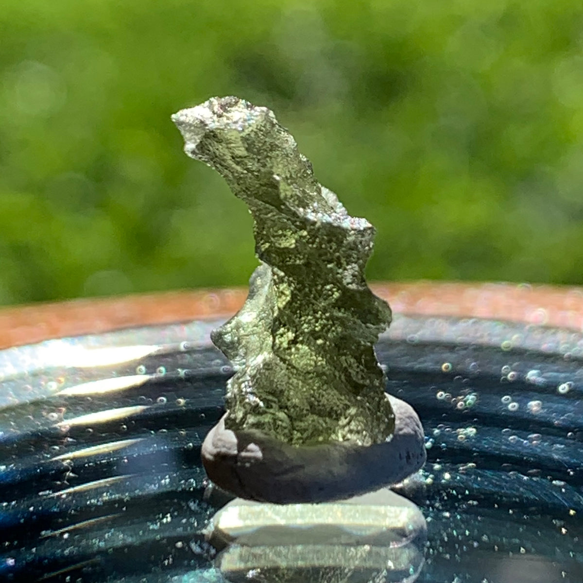 thin green besednice moldavite tektite on display