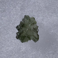 thin green besednice moldavite tektite on display