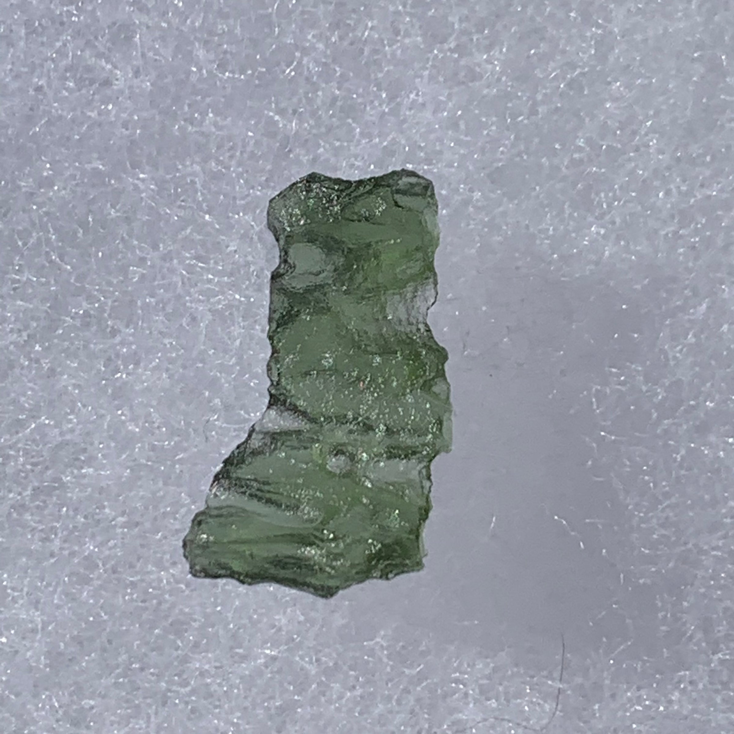 thin green besednice moldavite tektite on display