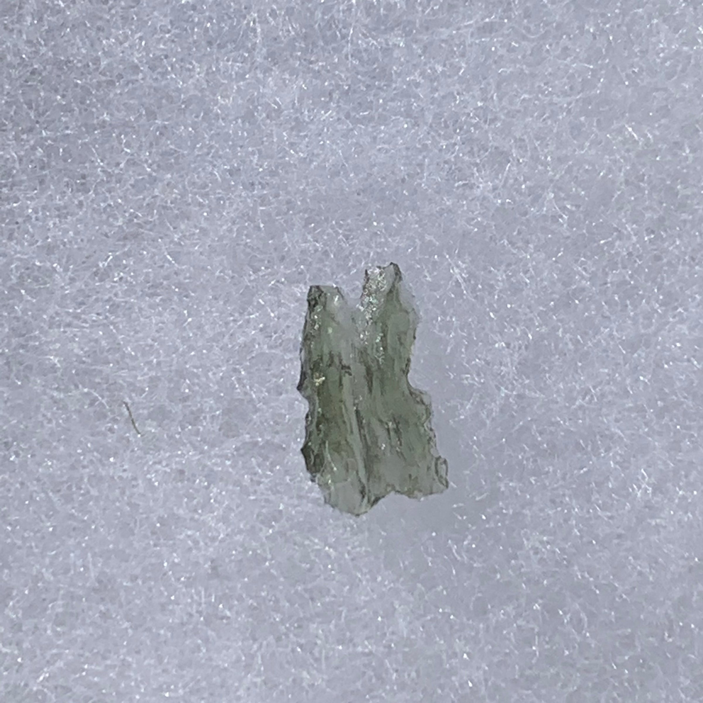 thin green besednice moldavite tektite on display