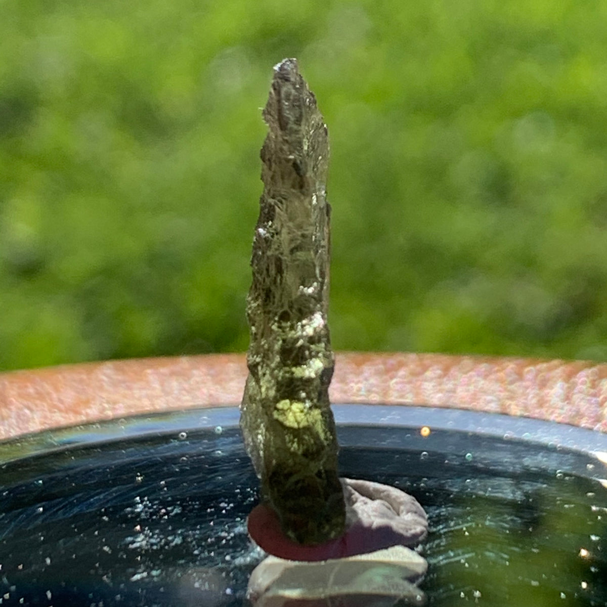 thin green besednice moldavite tektite on display