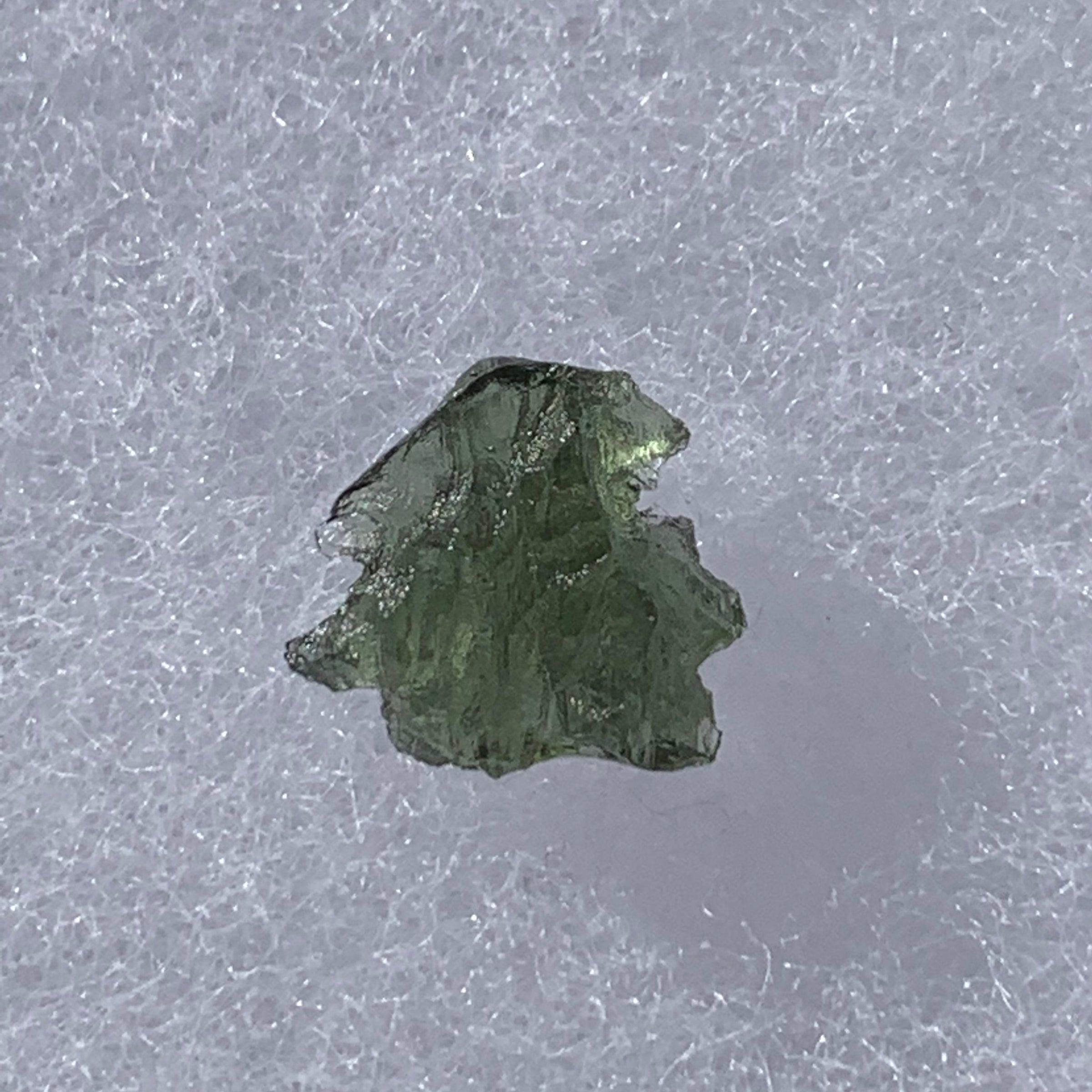 thin green besednice moldavite tektite on display