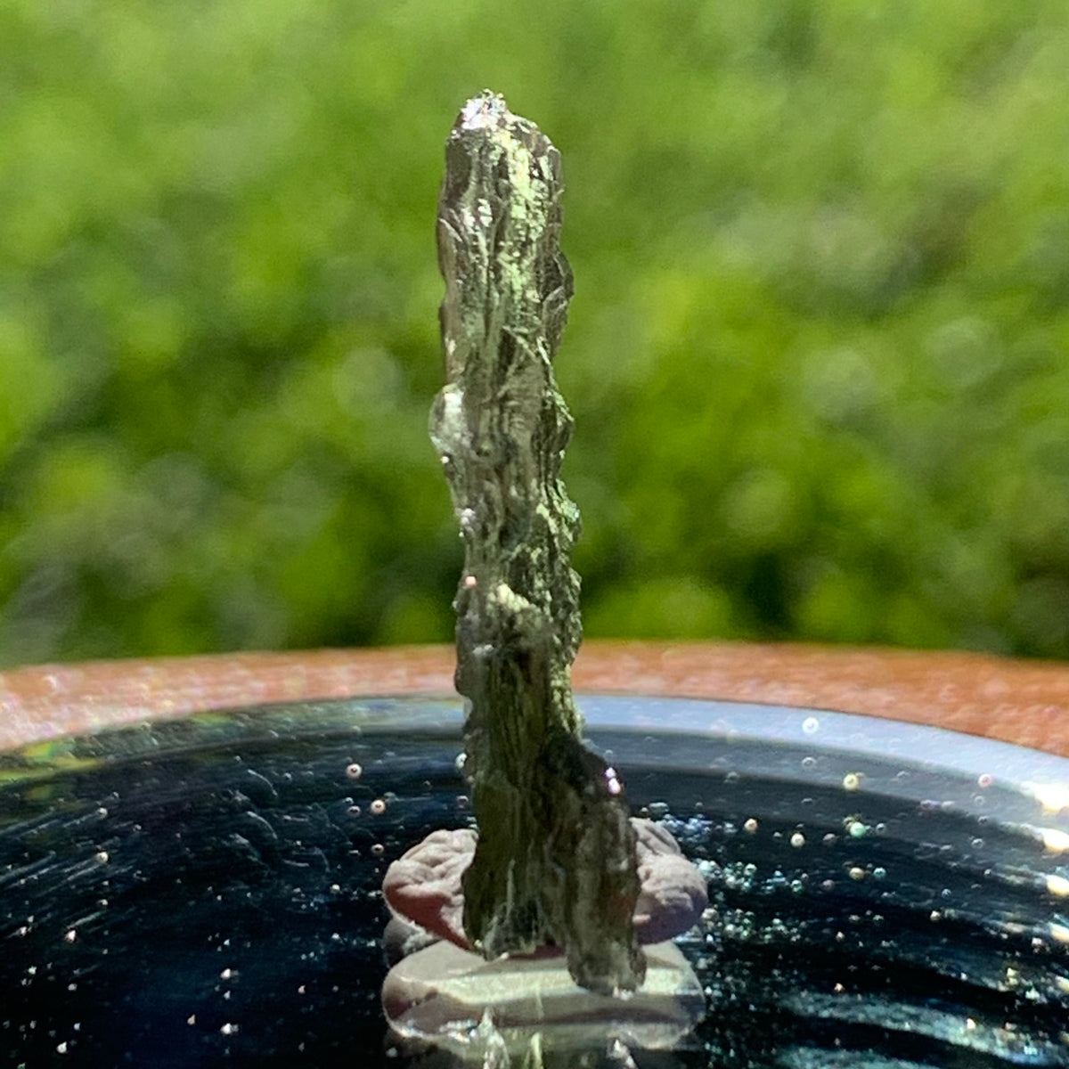 thin green besednice moldavite tektite on display