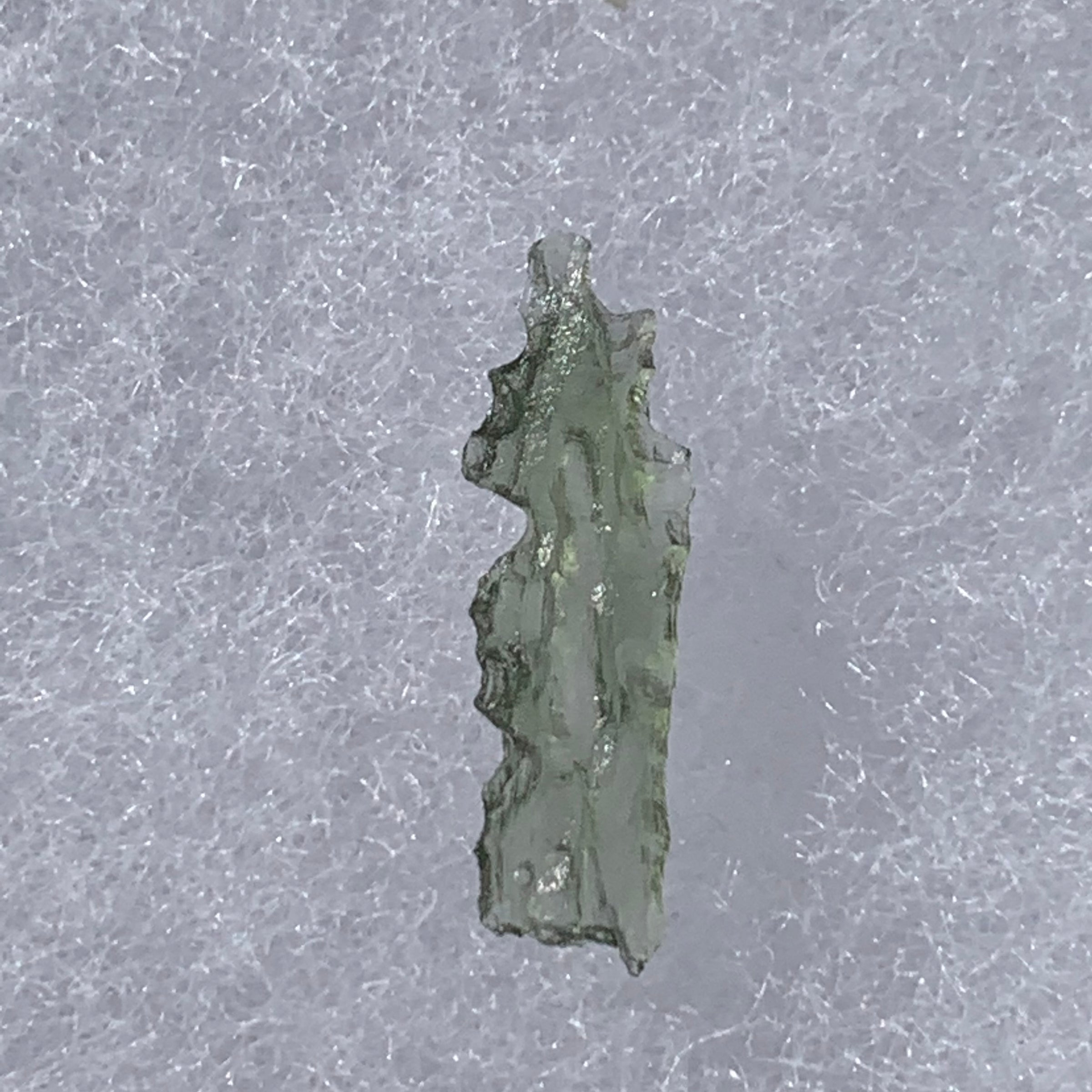 thin green besednice moldavite tektite on display