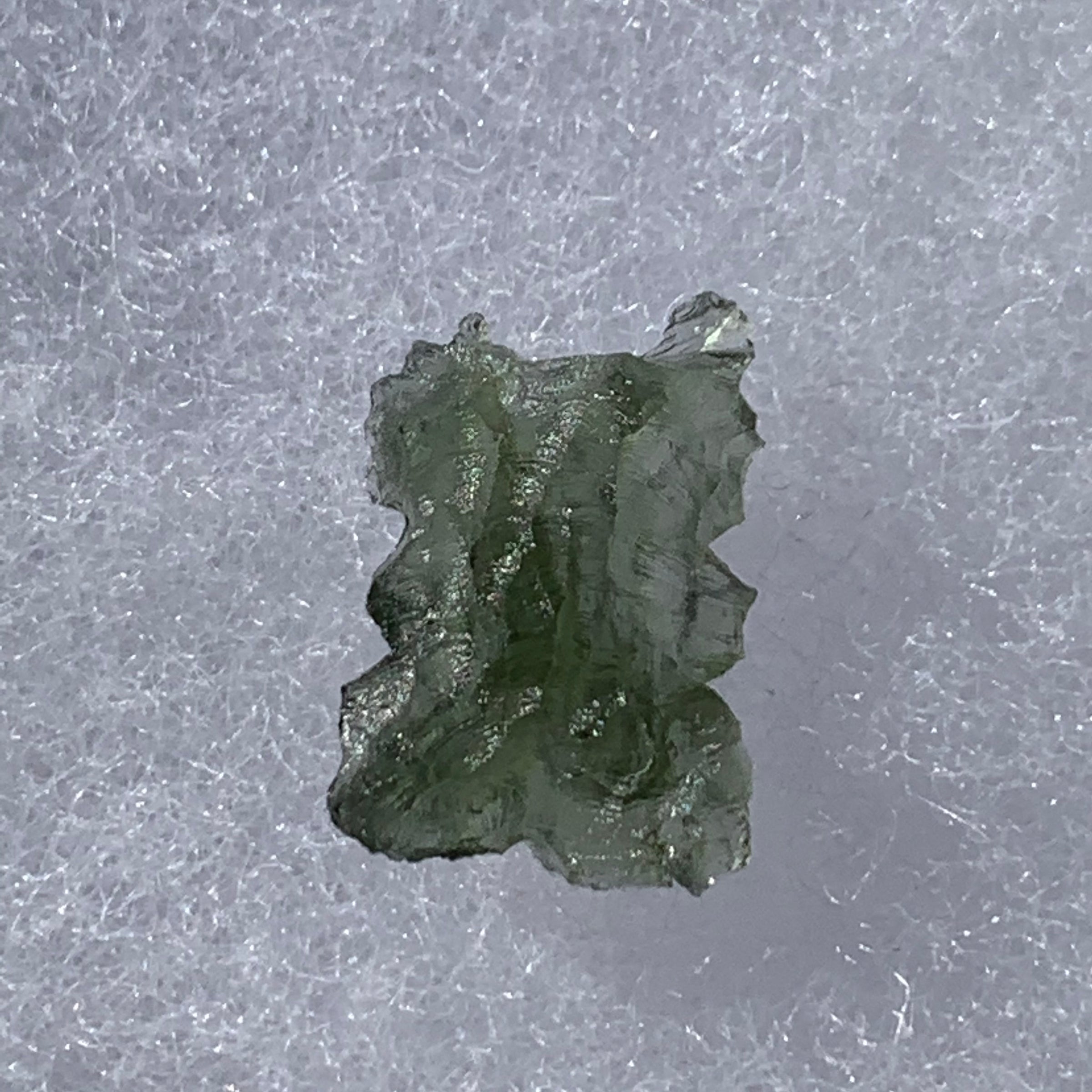 thin green besednice moldavite tektite on display