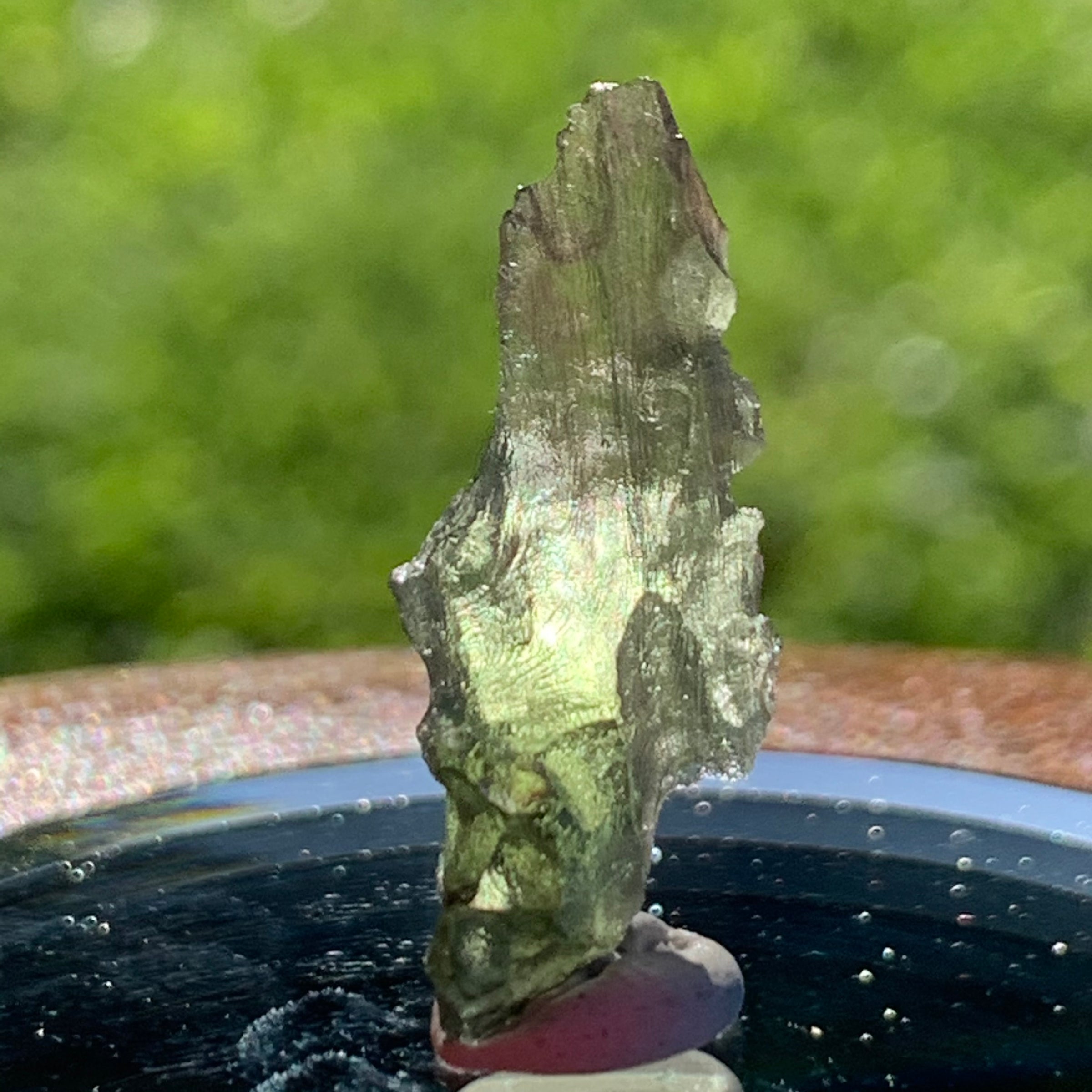 thin green besednice moldavite tektite on display