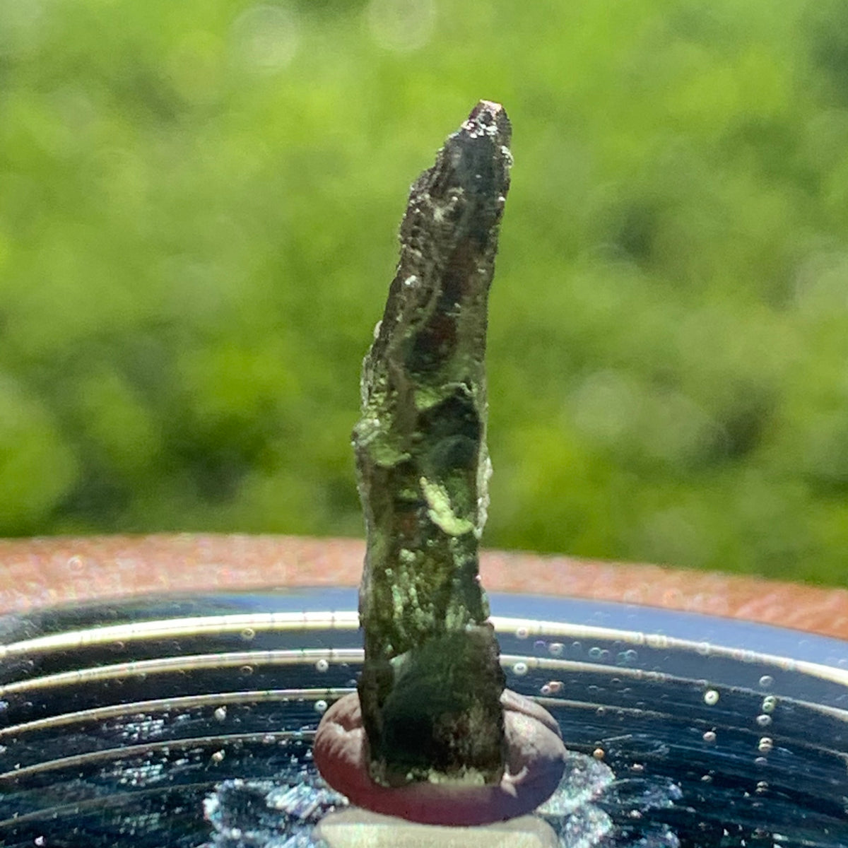 thin green besednice moldavite tektite on display