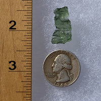 thin green besednice moldavite tektite next to a ruler and US quarter for scale