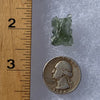 thin green besednice moldavite tektite next to a ruler and US quarter for scale