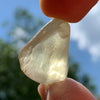 libyan desert glass is held up with sunlight shining through it