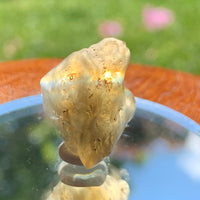 light reflects a rainbow through the libyan desert glass on display