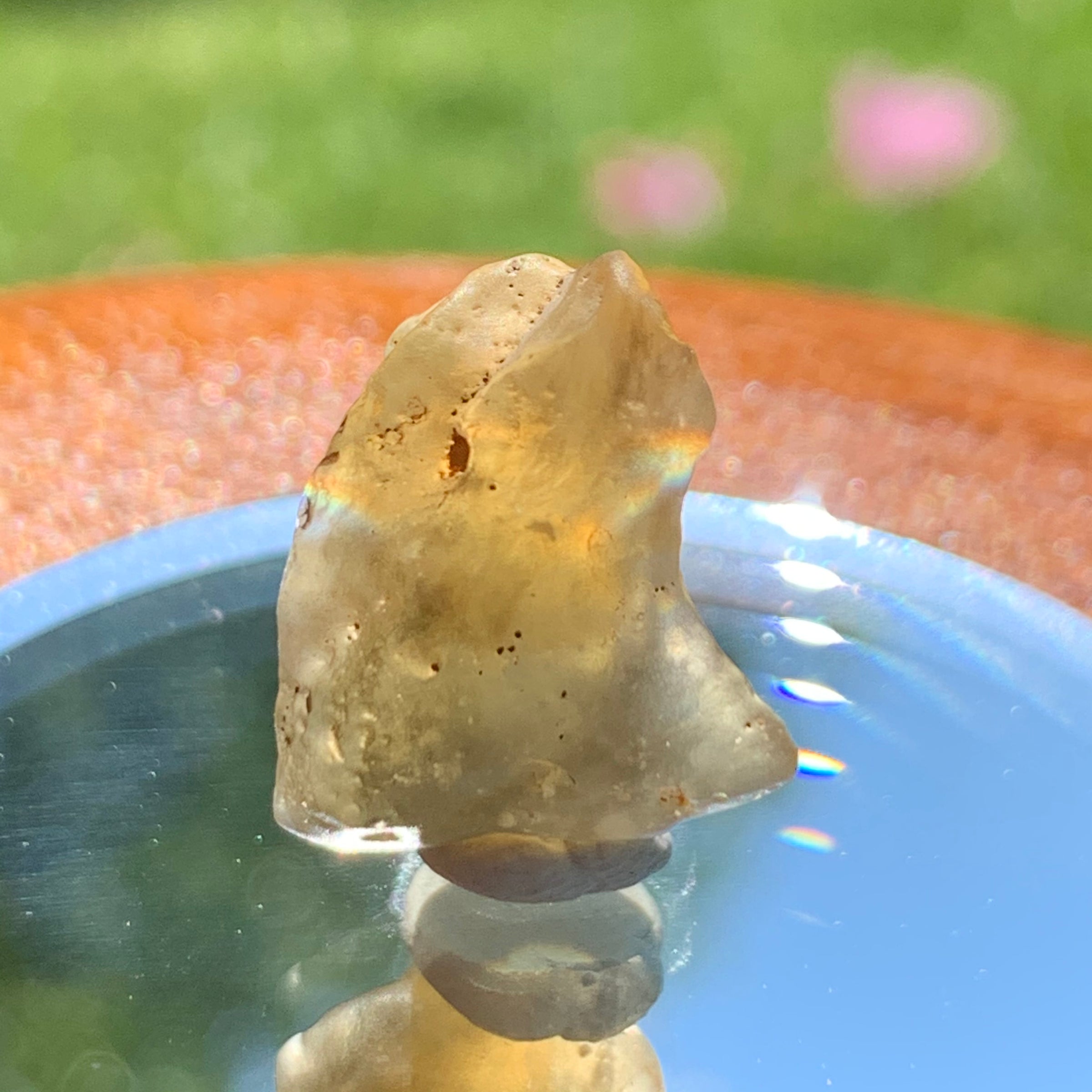 light reflects a rainbow through the libyan desert glass on display