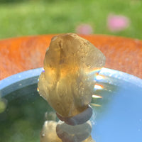 light reflects a rainbow through the libyan desert glass on display