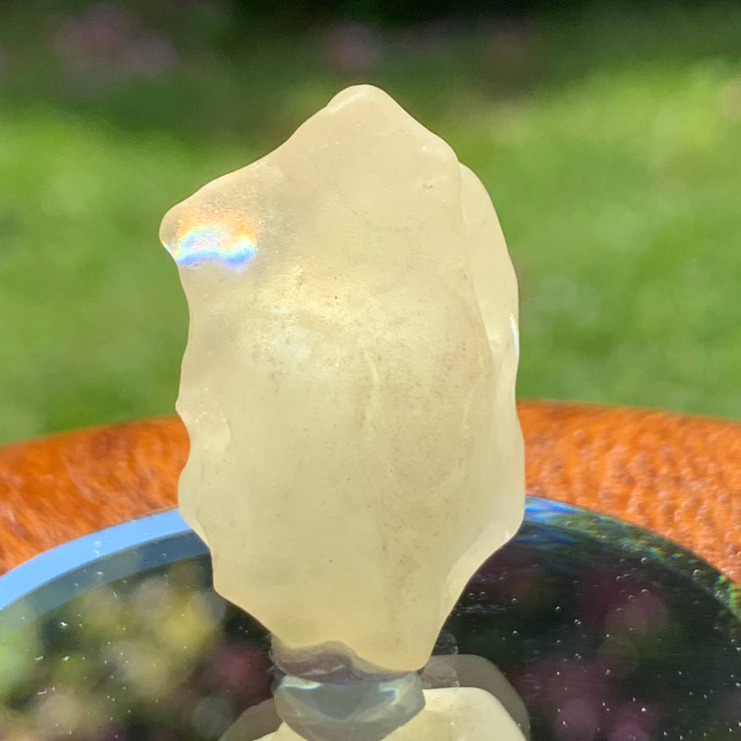 light reflects a rainbow through the libyan desert glass on display