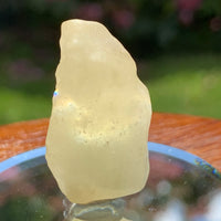 light reflects a rainbow through the libyan desert glass on display