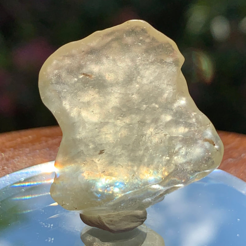 light reflects a rainbow through the libyan desert glass on display