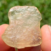 libyan desert glass details accentuated as it's held up with sunlight shining on it