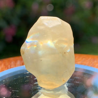 light reflects a rainbow through the libyan desert glass on display