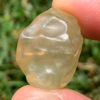 libyan desert glass is held up with sunlight shining on it