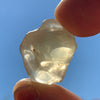 libyan desert glass is held up with sunlight shining through it