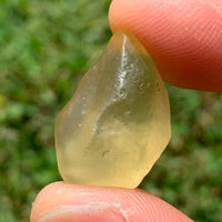 libyan desert glass is held up with sunlight shining on it