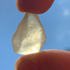 libyan desert glass is held up with sunlight shining through it