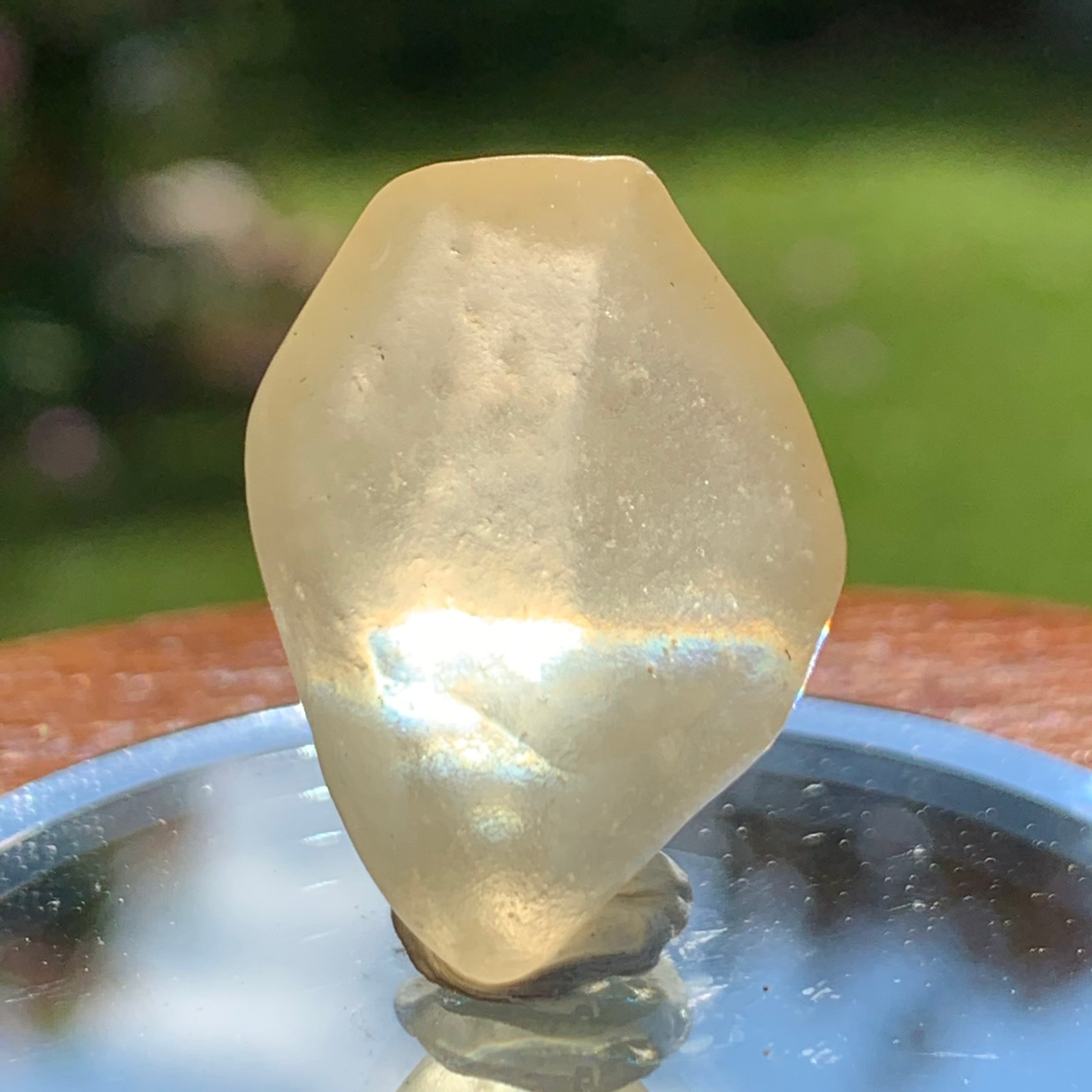 light reflects a rainbow through the libyan desert glass on display