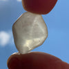 libyan desert glass is held up with sunlight shining through it