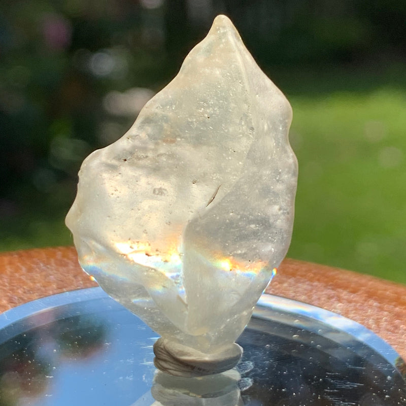 light reflects a rainbow through the libyan desert glass on display