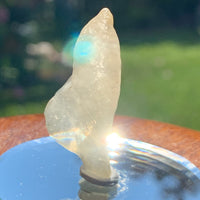 libyan desert glass on display with sun flares shining around it