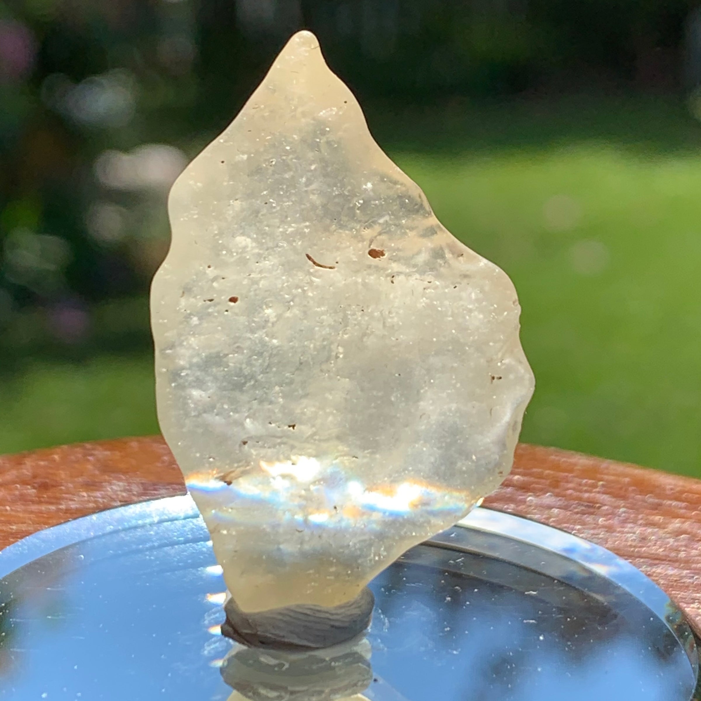 light reflects a rainbow through the libyan desert glass on display